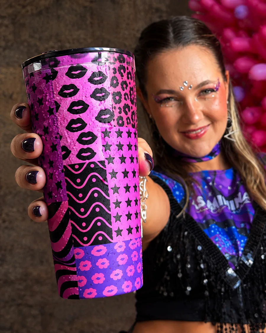 Mulher mostrando um copão rosa e preto com estampa de beijos e estrelas
